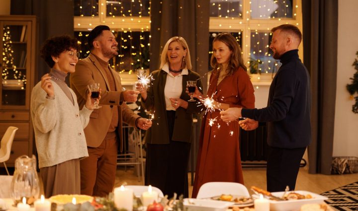 family celebrating christmas while holding burning sparklers