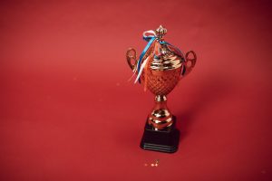 a trophy with tied ribbons on red background